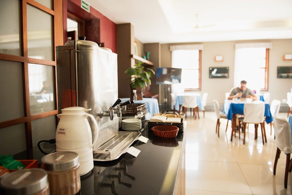 Máquina de café e o salão ao fundo