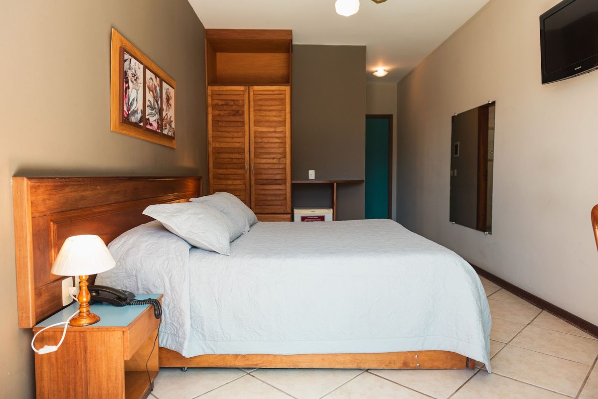 Especial com Ar: cama, TV e armário de madeira