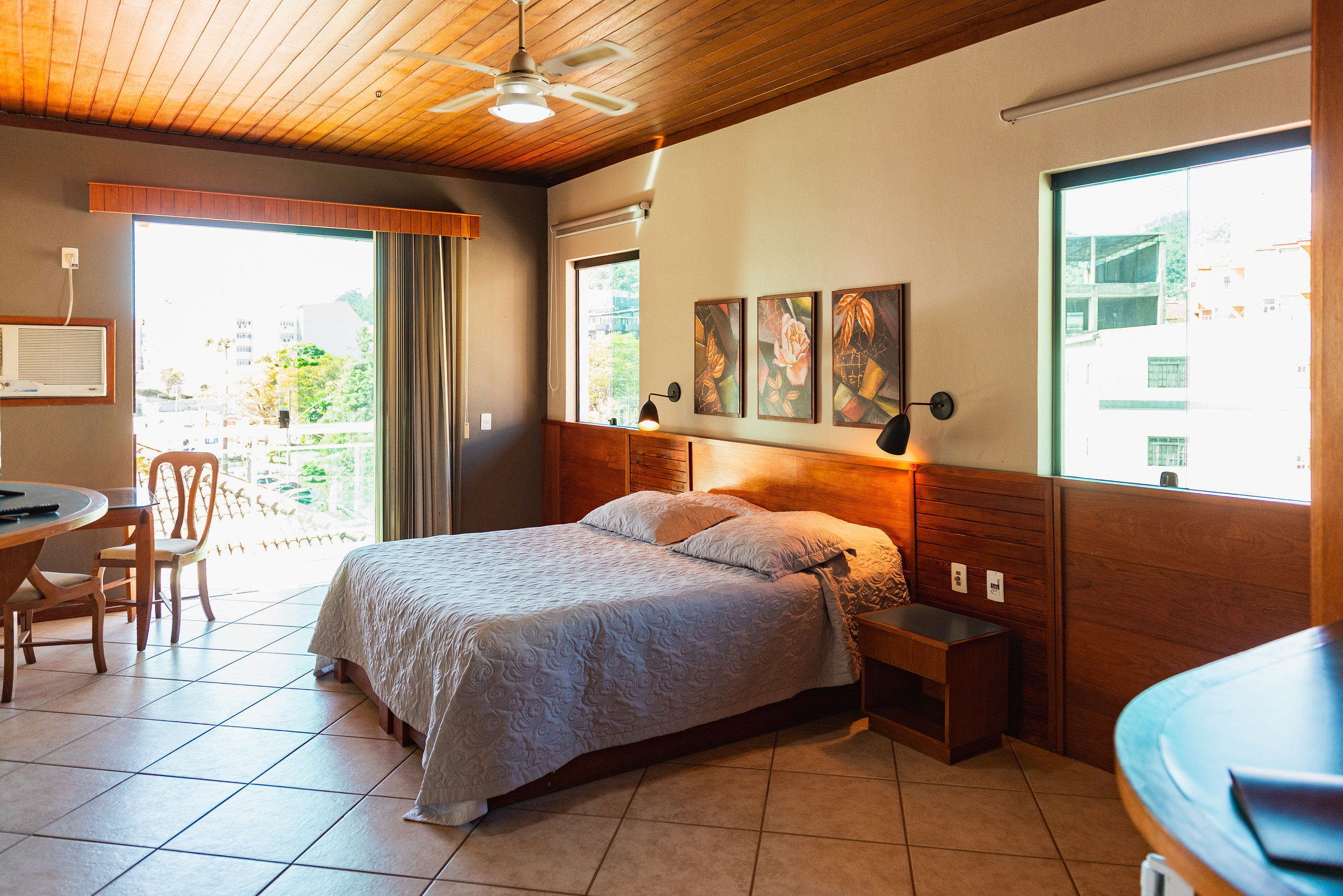 Suíte com Hidromassagem: cama, mesa de apoio e janelas