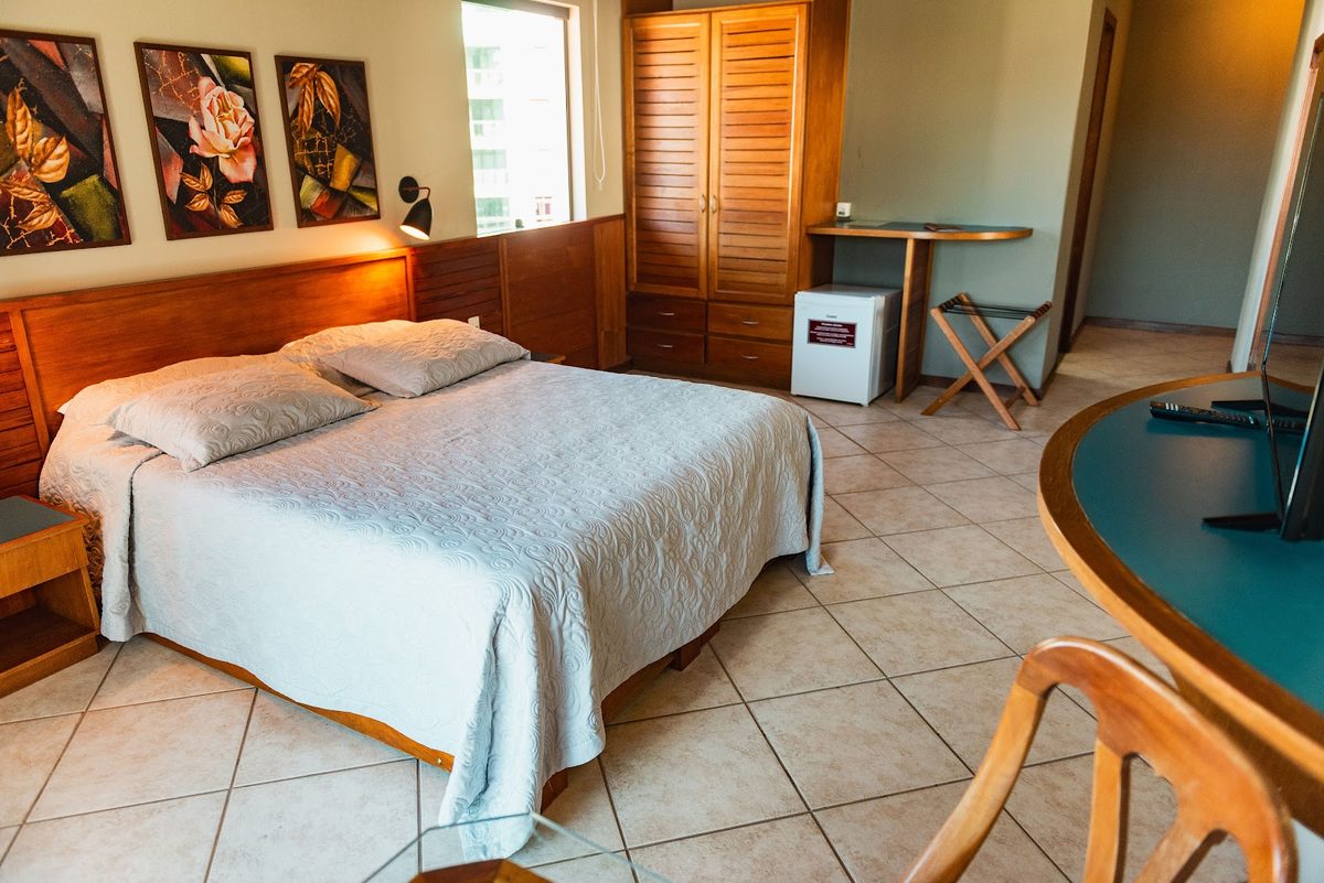 Suíte: cama, armário e mesa de refeições